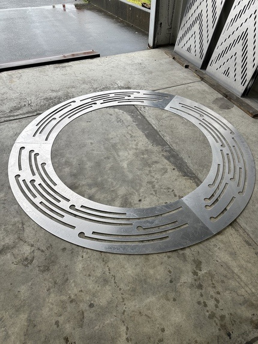 Circular Field: a circular perforated-metal ring element laid out on a concrete workshop floor